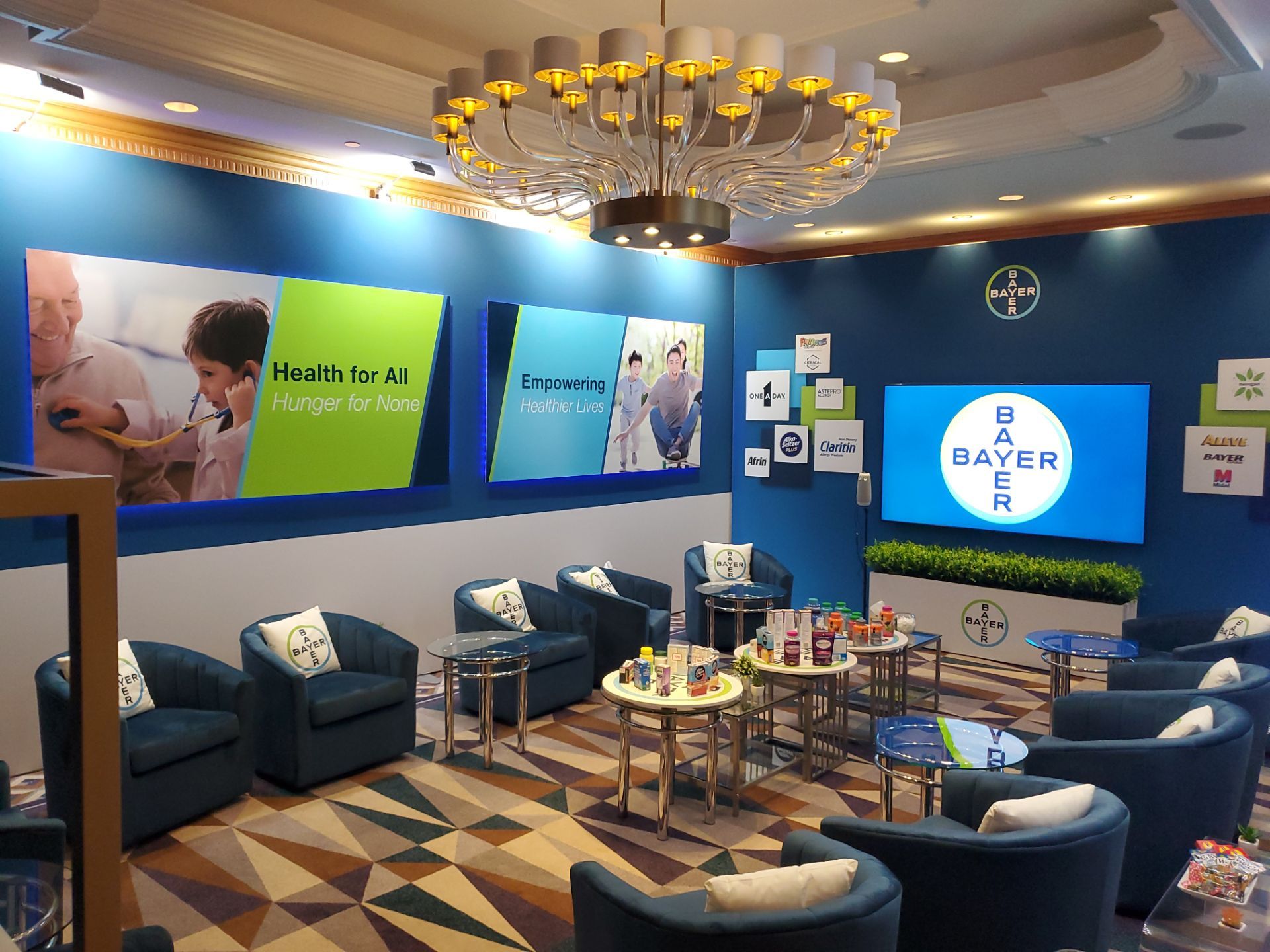Annual Meeting suite — digital screen with brand messaging and lounge seating