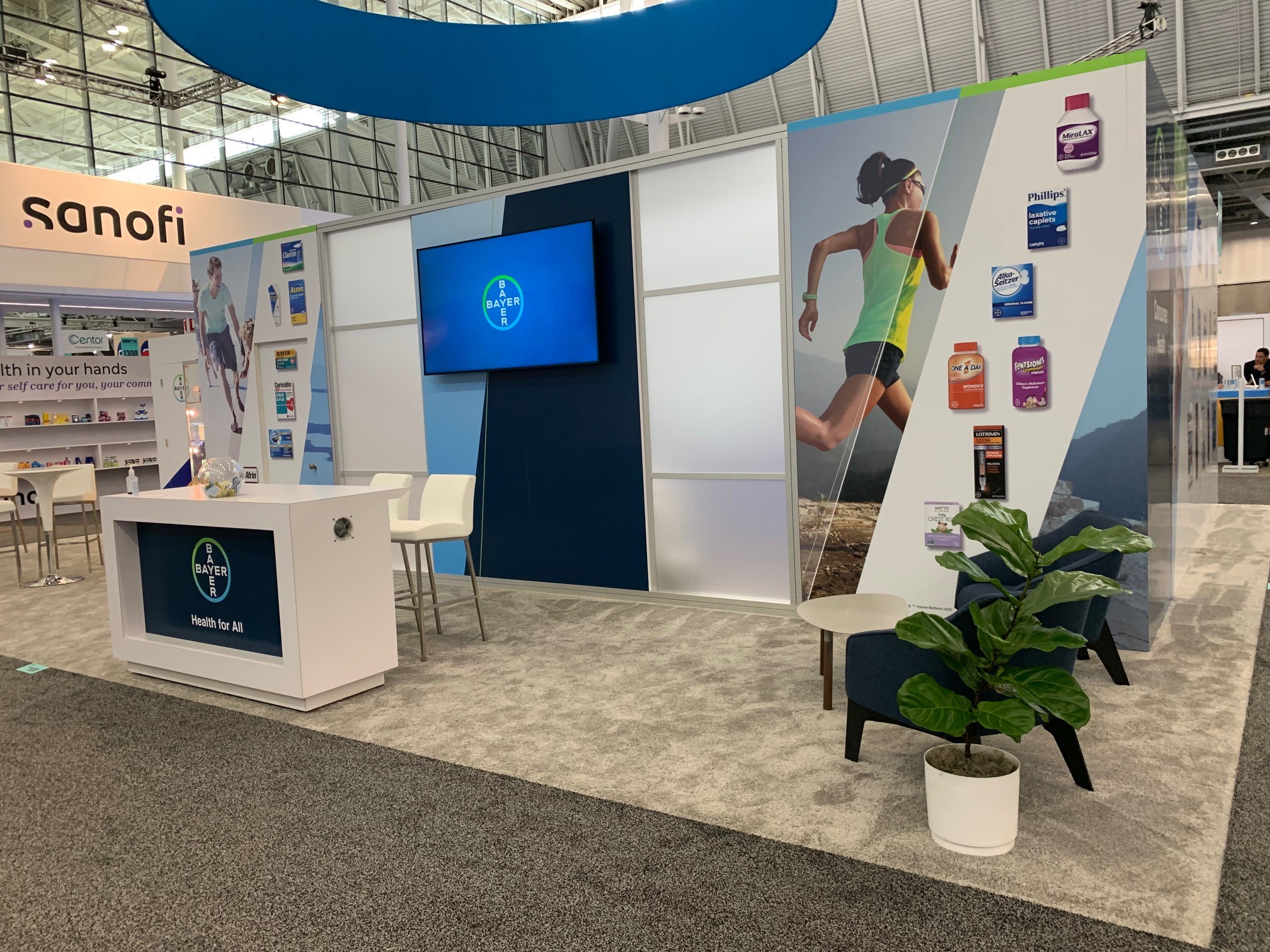 Bayer Consumer Health booth at NACDS TSE with Sanofi booth visible behind — competitive trade show environment